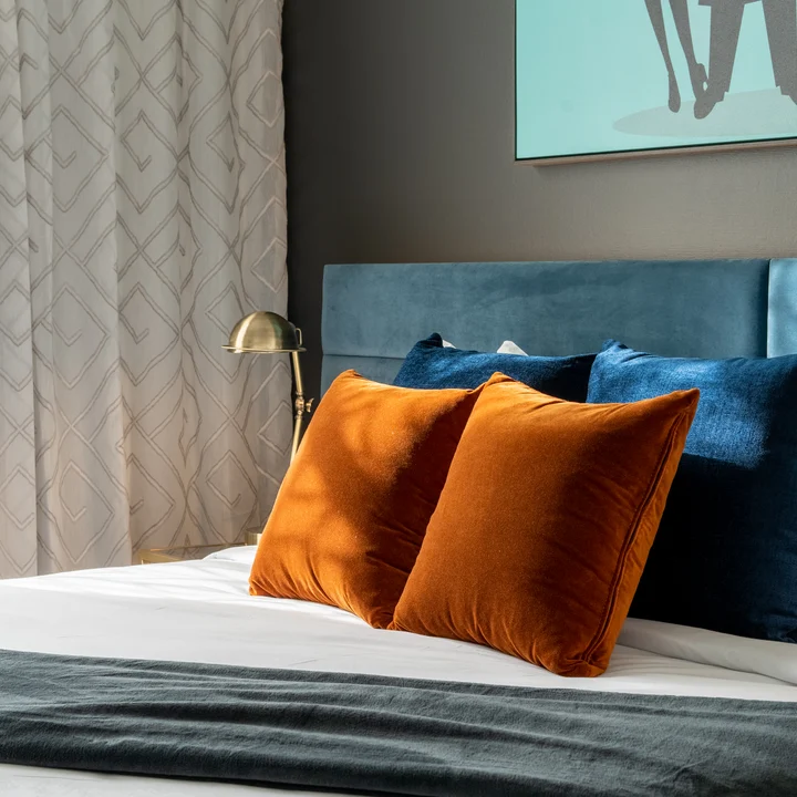 TRYP Hotel | Headboard in Lech colour Petrol by Zepel FibreGuard, throw pillows in Carter colour Midnight by James Dunlop and Lech colour Copper by Zepel FibreGuard, and curtains in Dadaism colour Putty by James Dunlop