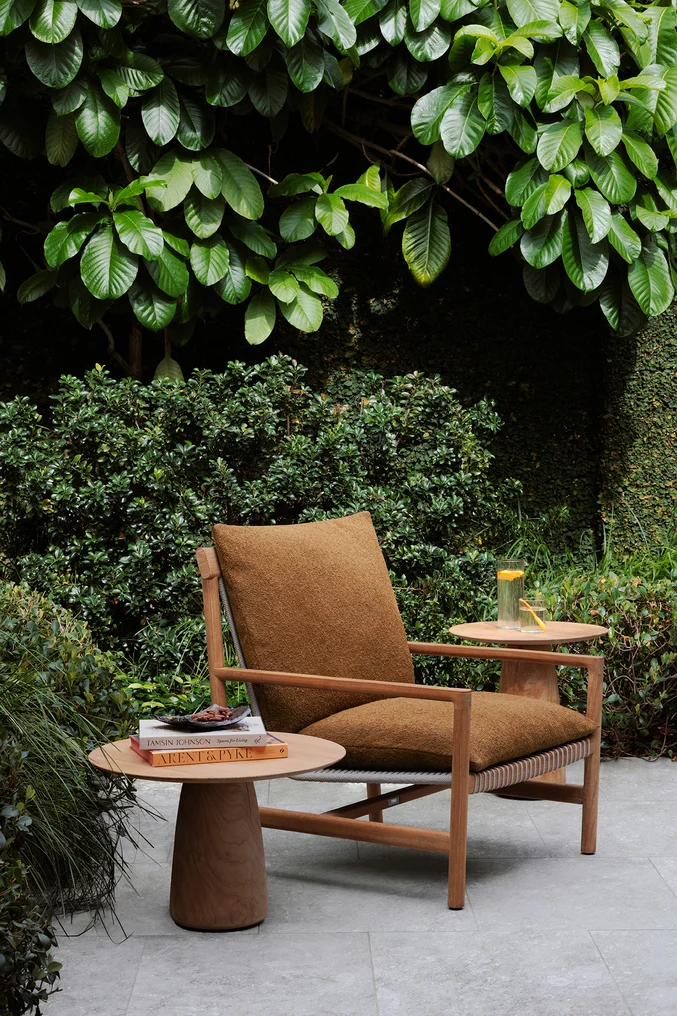 Modern terracotta boucle chair in lush outdoor setting