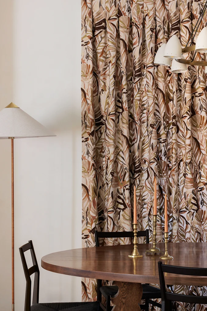 Crewel embroidered curtain fabric in tropical foliage design hung in contemporary dining room