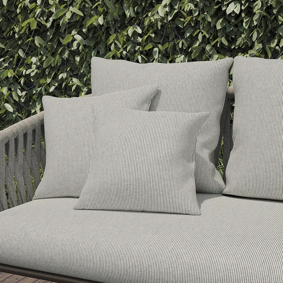 Striped outdoor sofa and cushions in lush setting