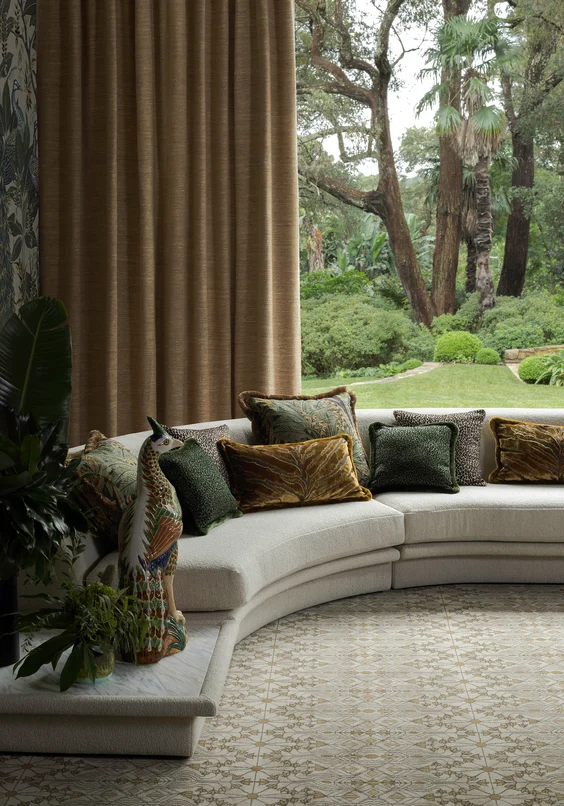 Curtain Tennessee Tussah colour Rose Gold, sofa Grande Boucle colour Champagne, cushions L-R Jungle Room colour Antique, Leopardo colours Palm Leaf and Tobacco, Bengal Tiger colour Gold