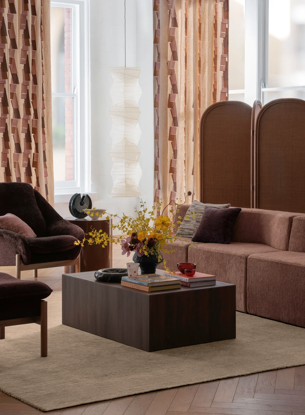 Curtains in Assemblage colour Burnt Umber, chairs in Modernist colour Mahogany, modular in Modernist colour Rust, cushions left to right in Modernist colour Blush, Impastare colour Bronze, Modernist colour Mahogany