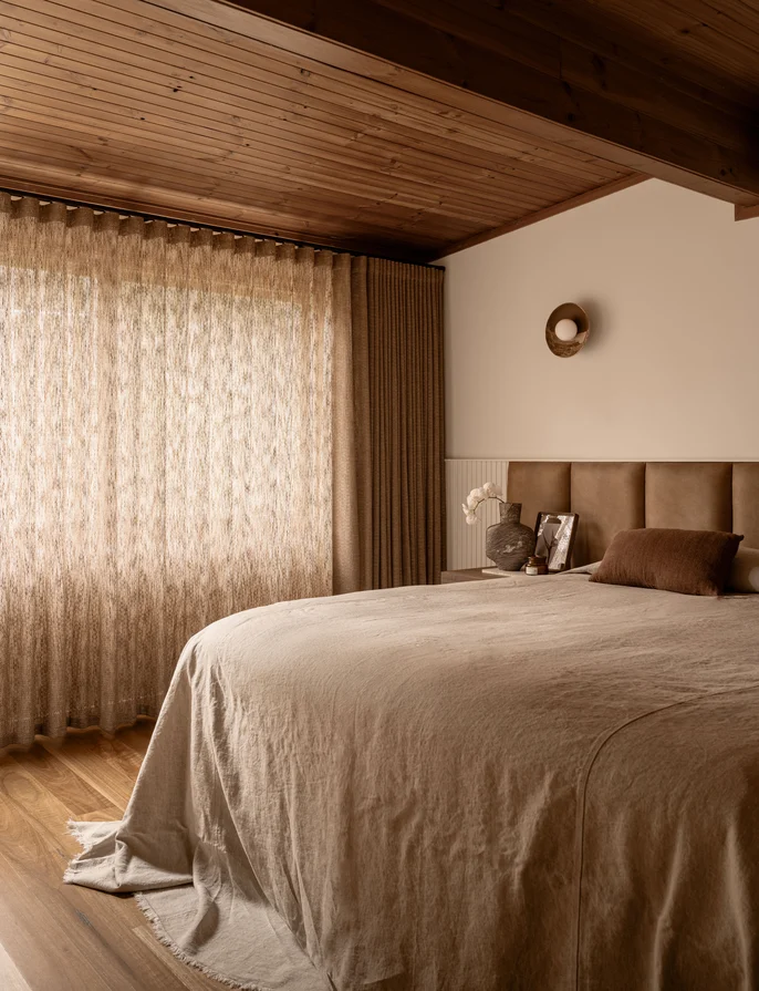 Open weave semi sheer drapery in a warm brown coloured bedroom