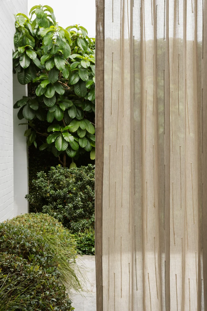 Irregular striped sheer curtain fabric in lush setting